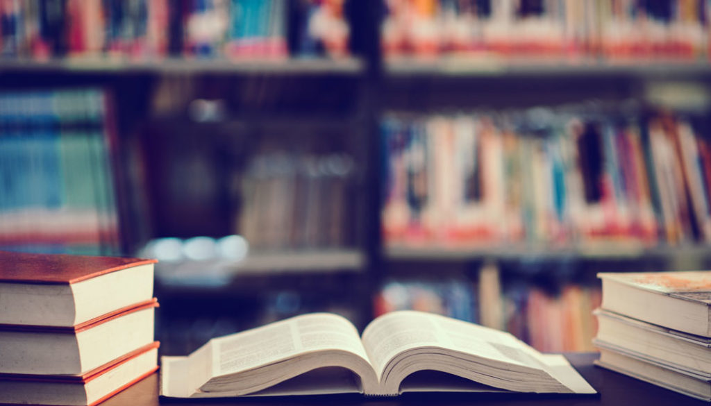 book-in-library-with-open-textbook