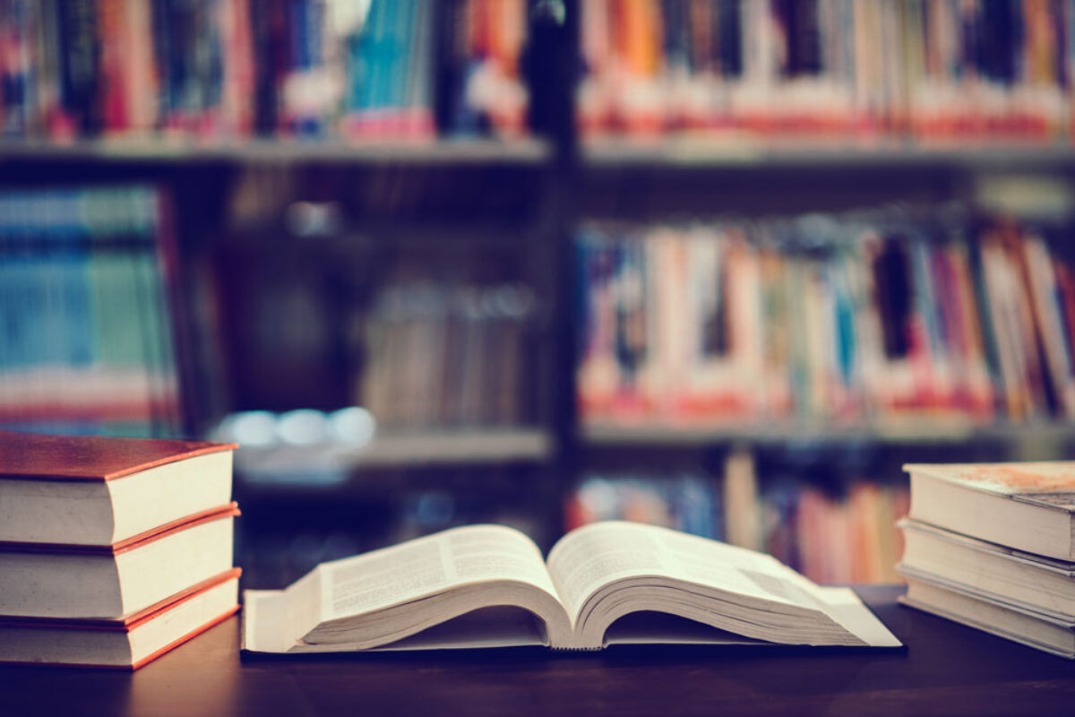 book-in-library-with-open-textbook