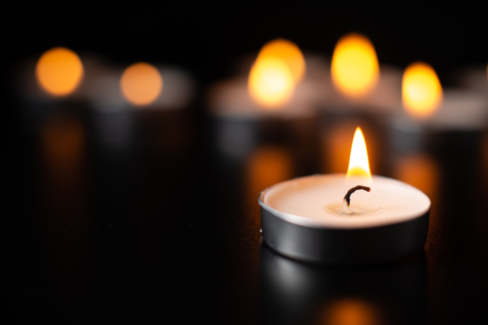front-view-of-burning-candles-on-pitch-black-surface