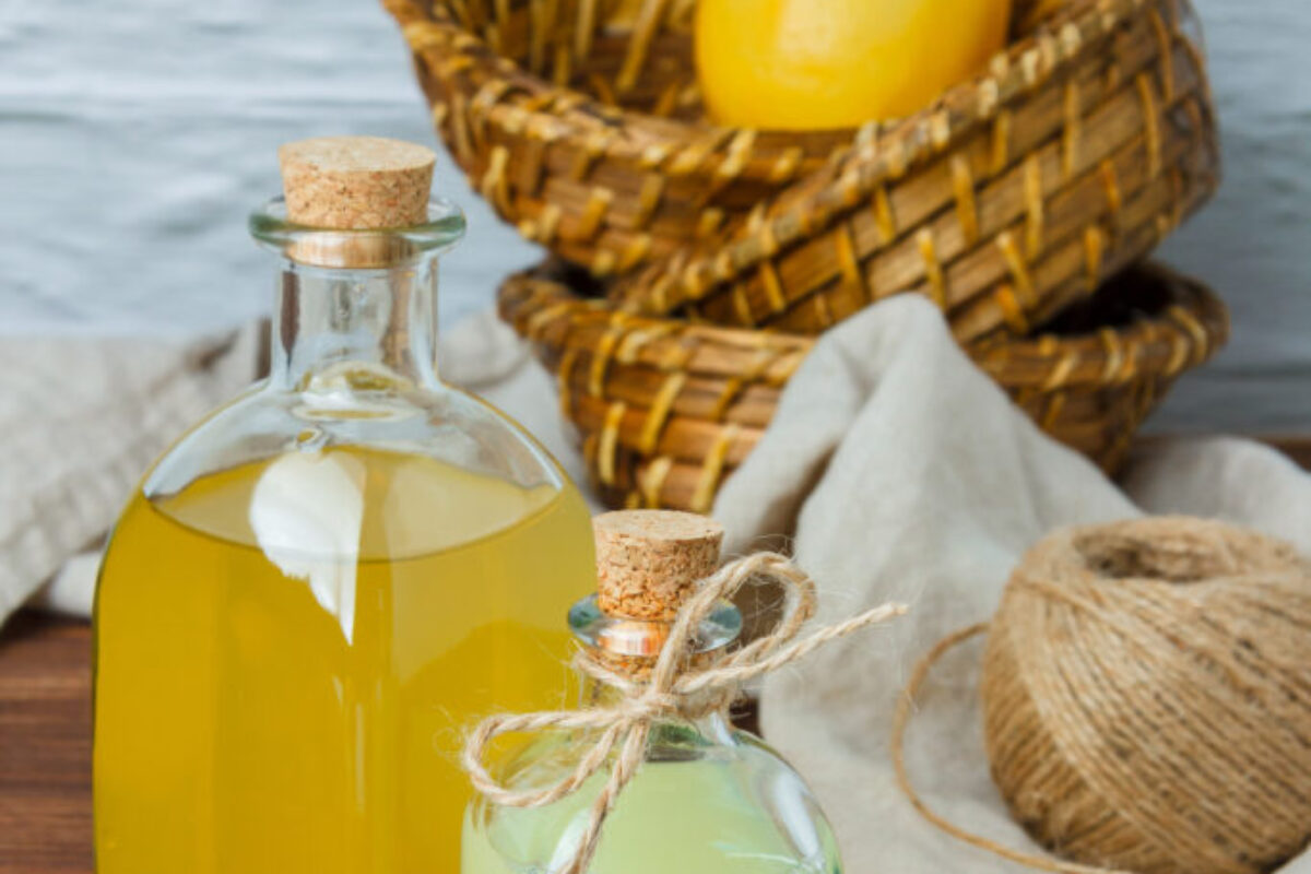 Set of on piece of white cloth, lemon leaves and lemon and juice in a basket on a wooden background. high angle view. space for text Set of on piece of white cloth, lemon leaves and lemon and juice in a basket on a wooden background. high angle view. space for text
