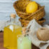 Set of on piece of white cloth, lemon leaves and lemon and juice in a basket on a wooden background. high angle view. space for text