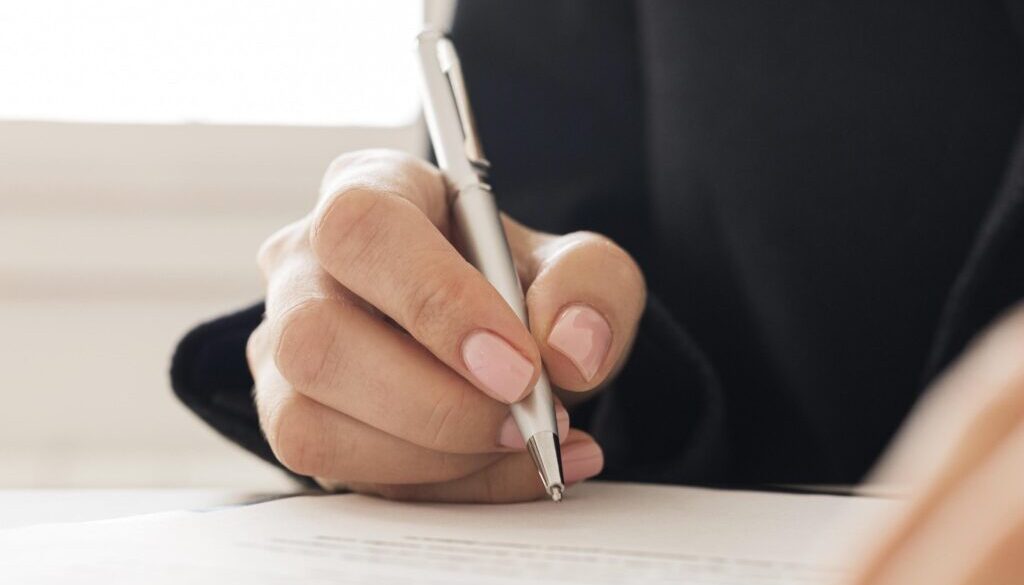 close-up-person-signing-certificate