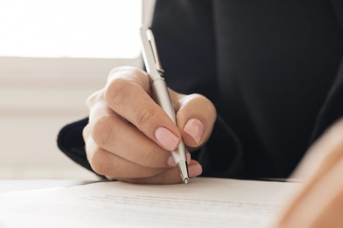 close-up-person-signing-certificate