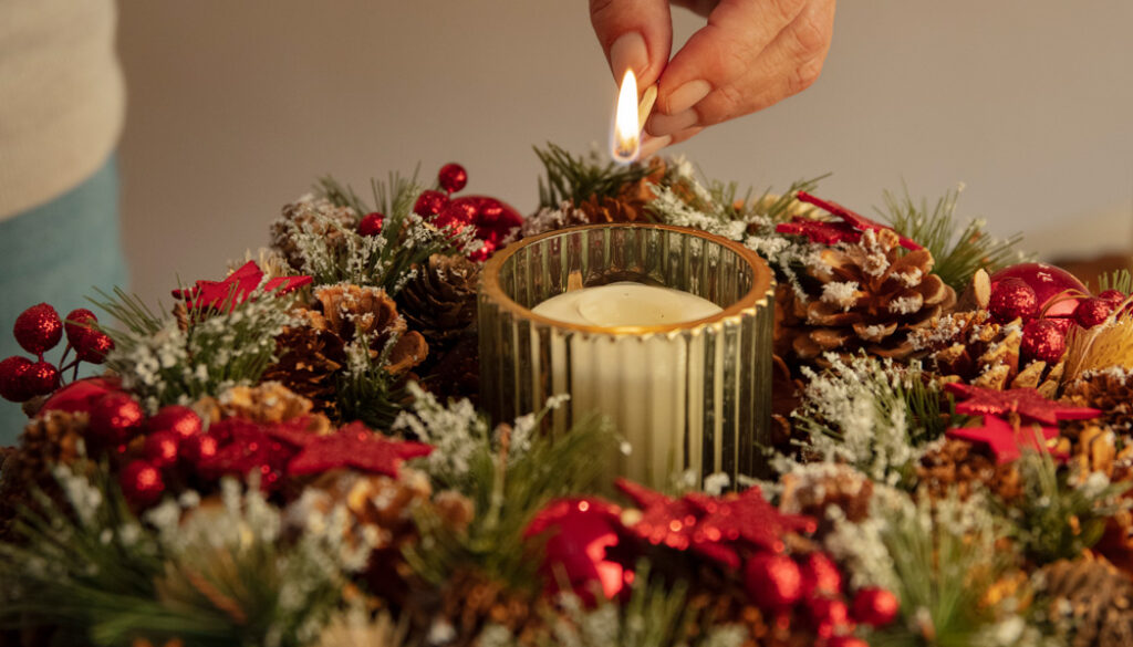 woman-lighting-wreath-candle-fire