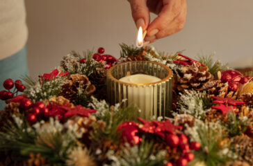 woman-lighting-wreath-candle-fire