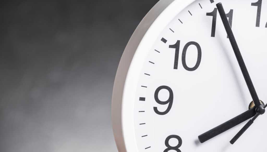 close-up-clock-face-against-gray-background