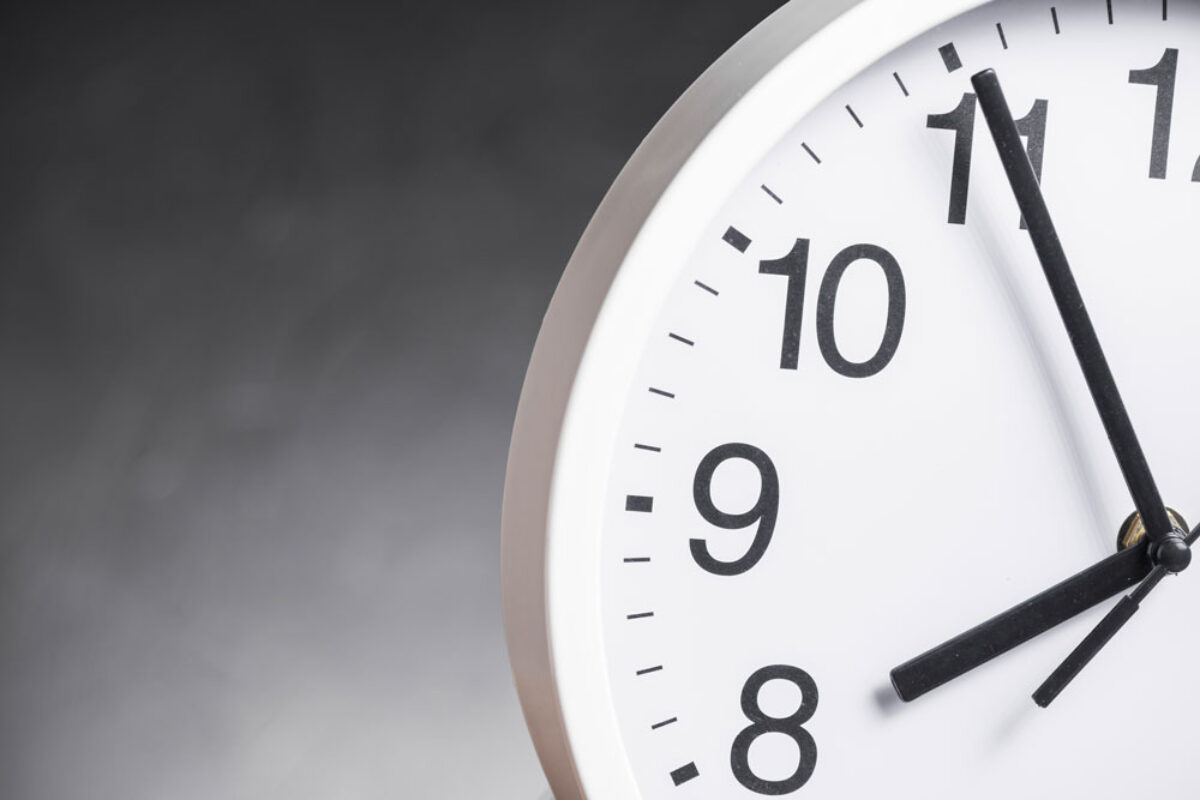 close-up-clock-face-against-gray-background