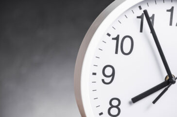 close-up-clock-face-against-gray-background